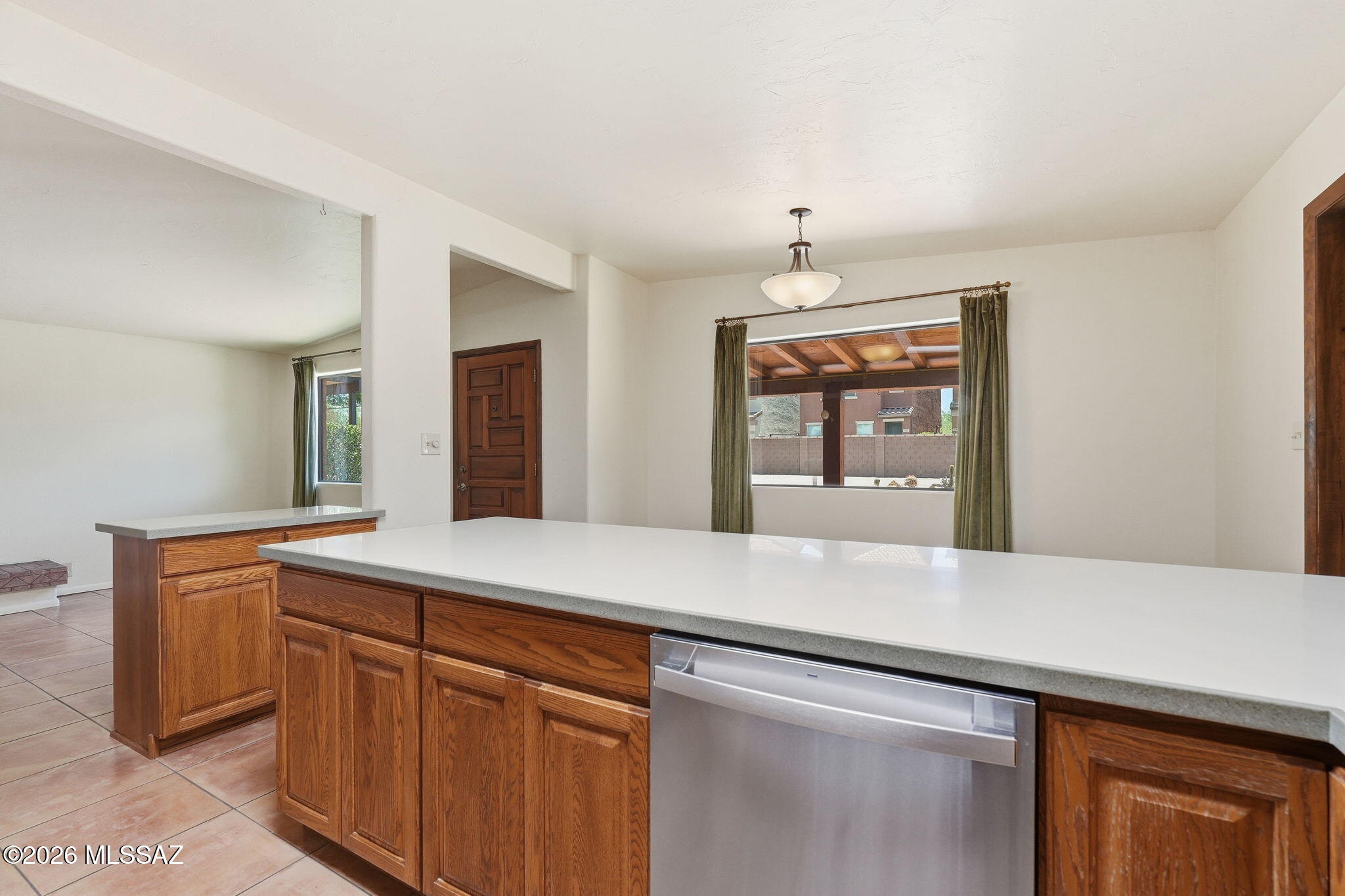 1125 East Kleindale Road Tucson, AZ 85719 - Photo 11 of 49 a kitchen with stainless steel appliances granite countertop a sink and dishwasher a refrigerator with wooden cabinets