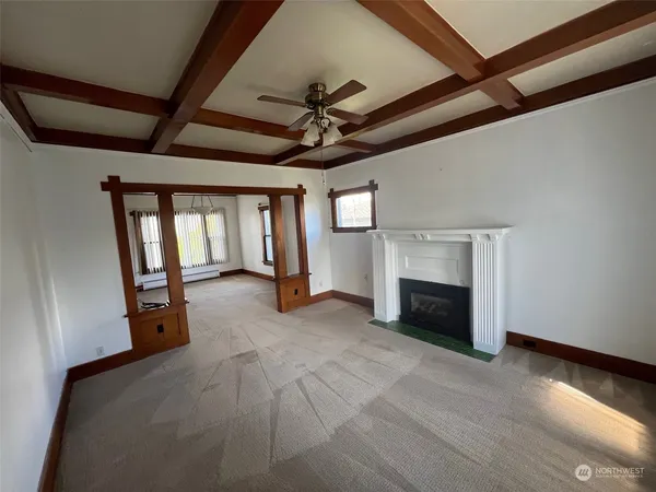 a view of an empty room with a fireplace and a window