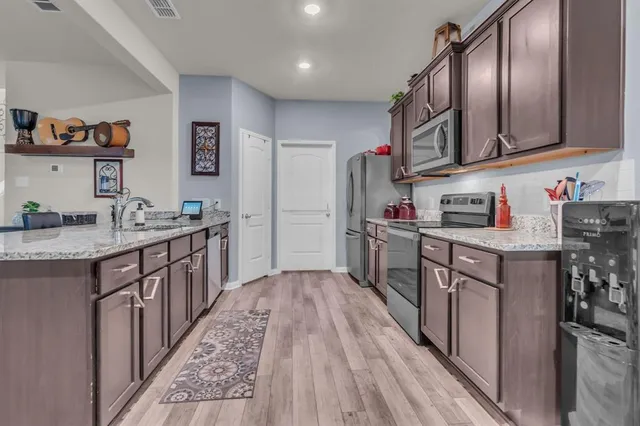 a kitchen with stainless steel appliances granite countertop a sink stove and cabinets