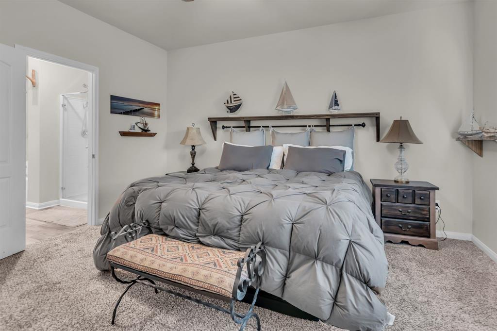 189 Point Rider Road Newark, TX 76071 - Photo 18 of 40 a bedroom with a bed a chair and potted plant on the dresser