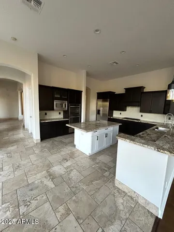 a large white kitchen with stainless steel appliances