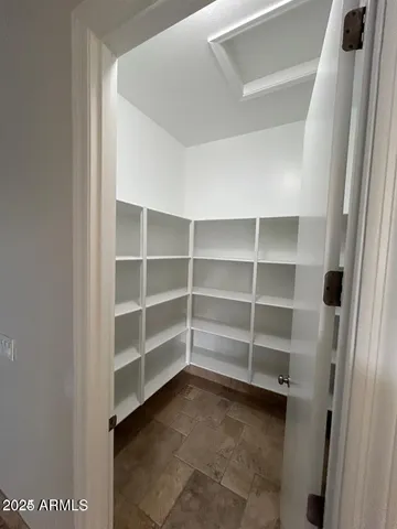 a view of walk in closet with empty racks