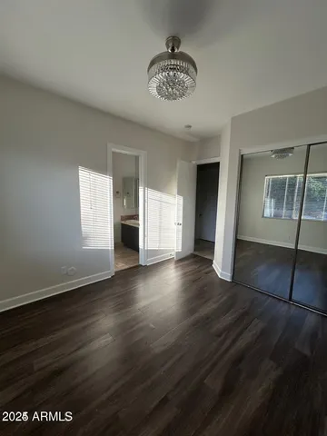 an empty room with wooden floor and window