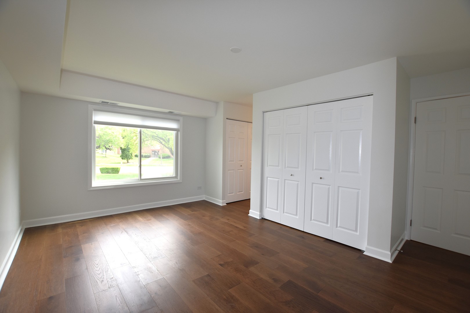 500 West Huntington Commons Road, Unit 157 Mount Prospect, IL 60056 - Photo 14 of 24 an empty room with wooden floor and windows