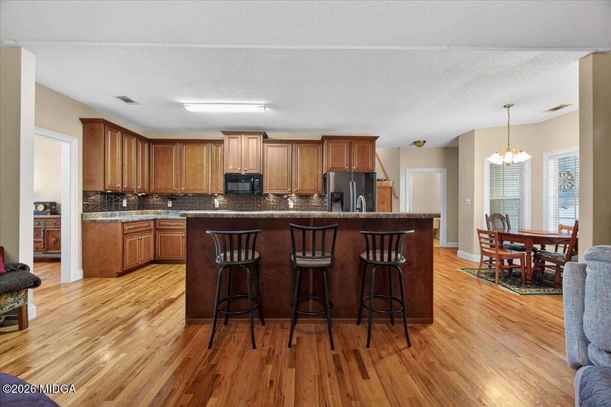 619 Grayridge Road Gray, GA 31032 - Photo 11 of 40 a kitchen with stainless steel appliances granite countertop wooden floors refrigerator and cabinets