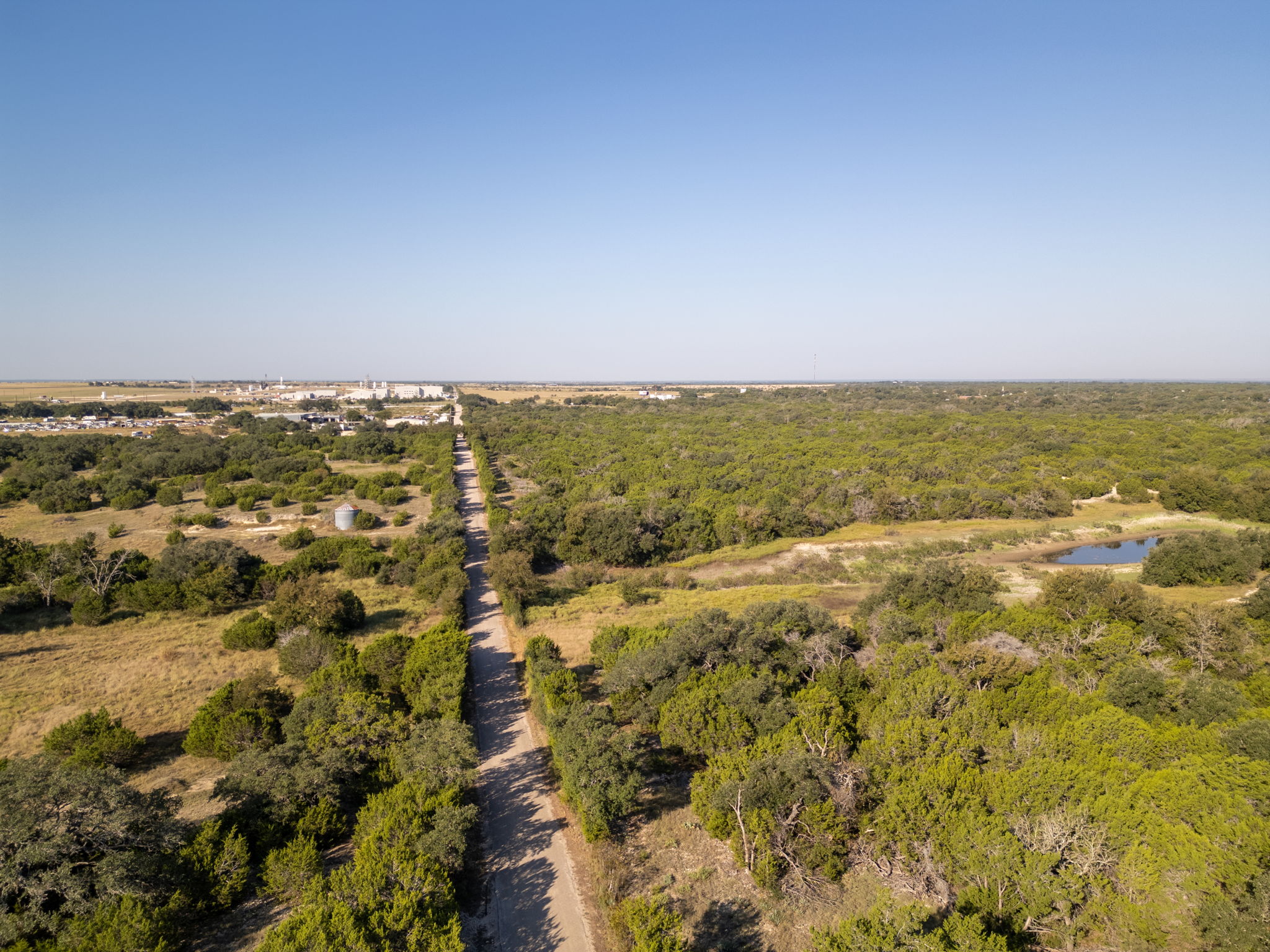 112 Loop 308 Briggs, TX 78608 - Photo 31 of 37 Bird's eye view of a forest and a nearby body of water