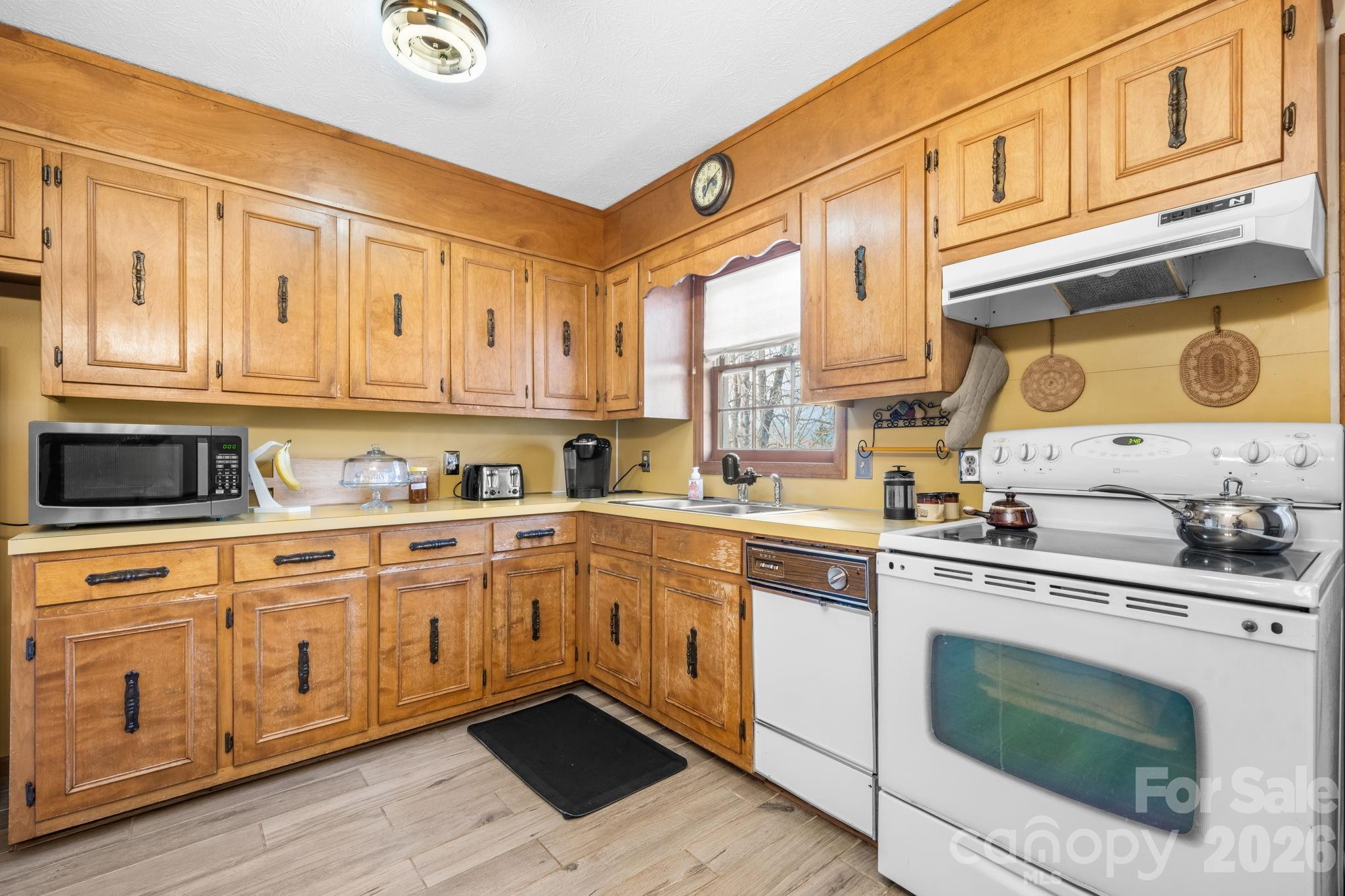 3384 Sheely Road Lenoir, NC 28645 - Photo 16 of 27 a kitchen with stainless steel appliances granite countertop a stove and white cabinets