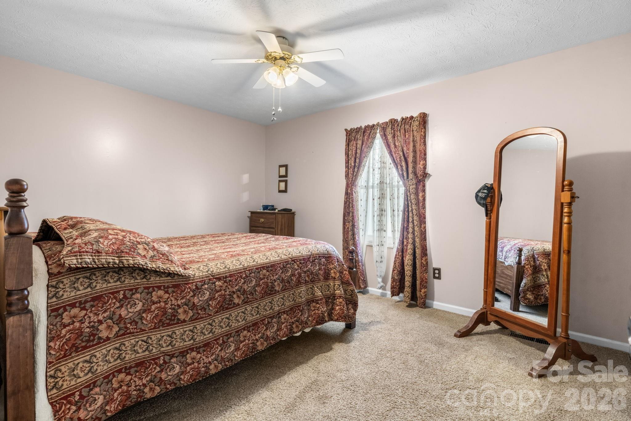 3384 Sheely Road Lenoir, NC 28645 - Photo 18 of 27 a bedroom with a bed a chandelier and a dresser