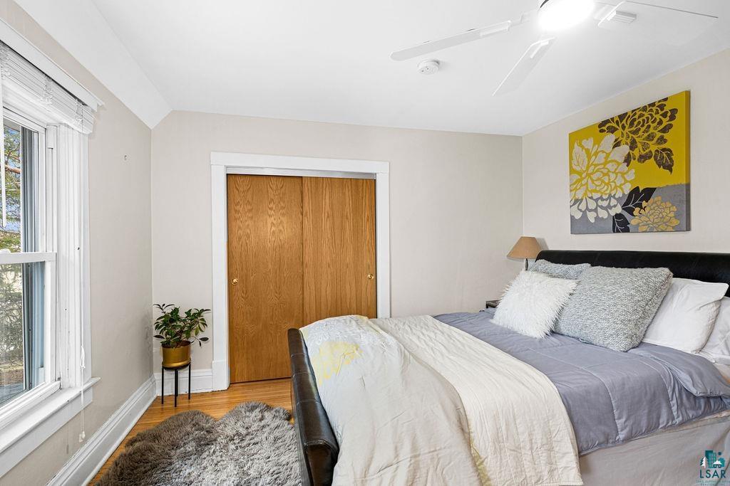3206 Minnesota Avenue Duluth, MN 55802 - Photo 17 of 51 Bedroom featuring wood-finish flooring, a double-hung window with blinds, and white trim throughout