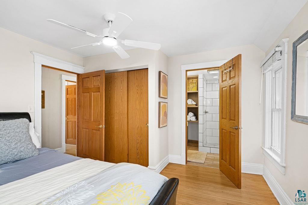3206 Minnesota Avenue Duluth, MN 55802 - Photo 18 of 51 Bedroom featuring light wood-finish flooring, a white ceiling fan, and a paneled wood door