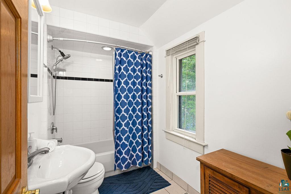 3206 Minnesota Avenue Duluth, MN 55802 - Photo 25 of 51 Full bathroom featuring a white tile shower-over-tub with a black accent band, a pedestal sink, and tile flooring