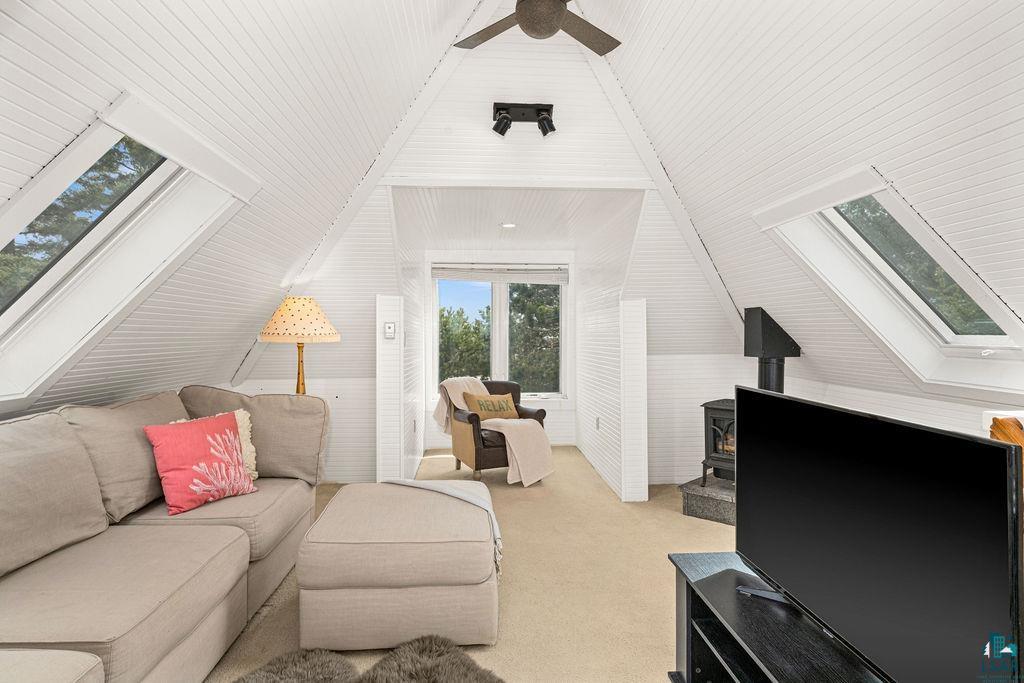 3206 Minnesota Avenue Duluth, MN 55802 - Photo 28 of 51 Vaulted ceiling with white planking and dual skylights, featuring a ceiling fan, a window seat with a casement window, and a built-in gas fireplace