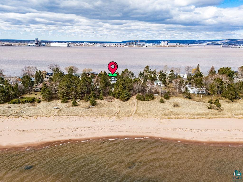 3206 Minnesota Avenue Duluth, MN 55802 - Photo 40 of 51 Waterfront property featuring a sandy beach, mature evergreen trees, a clear water body, and distant cityscape