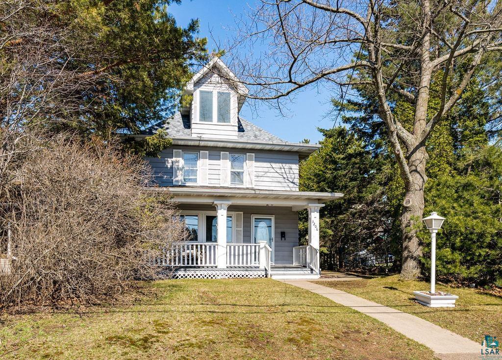3206 Minnesota Avenue Duluth, MN 55802 - Photo 4 of 51 Charming three-story residence featuring a covered front porch with white railings, a dormer window, and a light-colored exterior with shutters