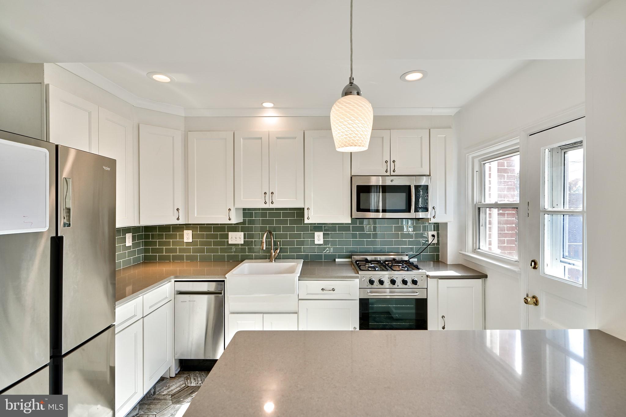 1433 Cedarcroft Road Baltimore, MD 21239 - Photo 10 of 30 a kitchen with stainless steel appliances white cabinets a stove a sink and a refrigerator