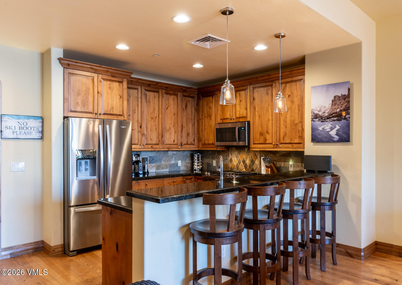 300 Prater Road, Unit B103 Avon, CO 81620 - Photo 11 of 17 a kitchen with stainless steel appliances granite countertop a refrigerator a stove a sink a dining table and chairs with wooden floor