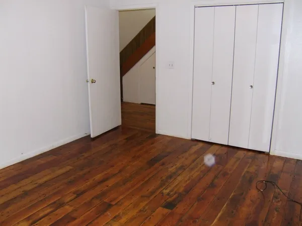 a view of an empty room with wooden floor