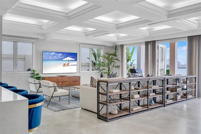 a large living room with furniture a large window and a chandelier