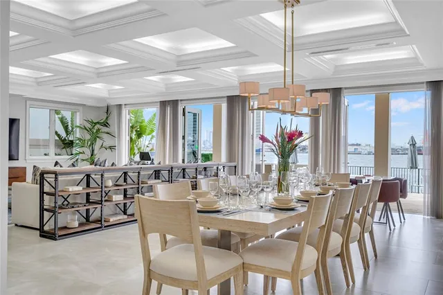 a dining room with furniture large windows and a chandelier