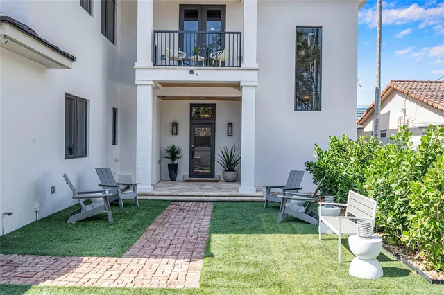 a view of a chair and table in backyard of the house