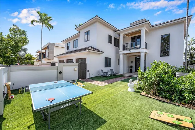 a backyard of a house with table and chairs