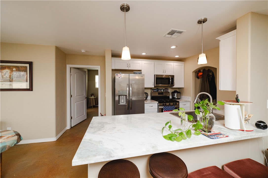 2948 Pinal Road Golden Valley, AZ 86413 - Photo 11 of 59 Kitchen featuring a spacious island with a light-toned countertop, stainless steel appliances, white cabinetry, recessed lighting, and pendant lights
