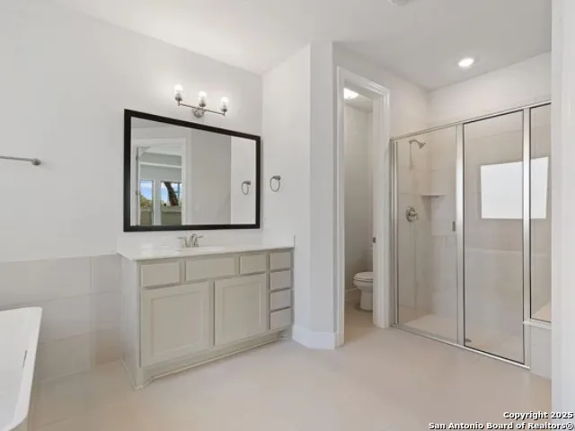 a bathroom with a double vanity sink mirror and shower