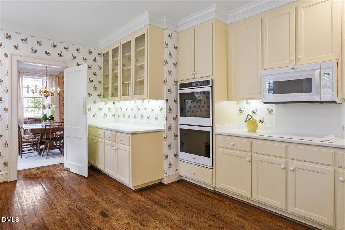 1128 Harvey Street Raleigh, NC 27608 - Photo 15 of 41 a kitchen with stainless steel appliances white cabinets and wooden floors