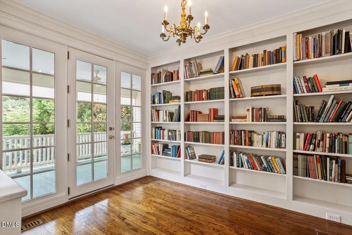 1128 Harvey Street Raleigh, NC 27608 - Photo 19 of 41 a living room with hard wood floors and a book shelf