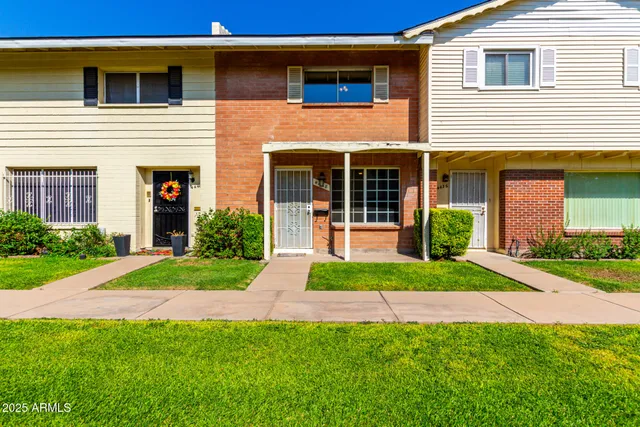 a view of a house with brick walls and a yard with plants