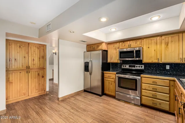 a kitchen with stainless steel appliances granite countertop a refrigerator and a stove top oven