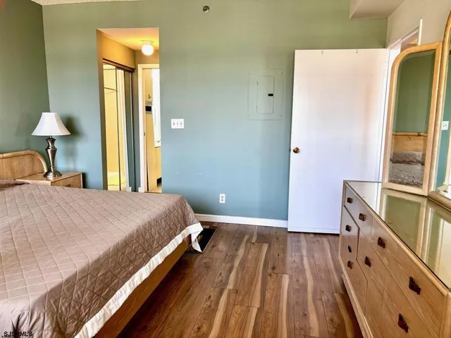 a bedroom with a bed and a flat tv screen on dresser