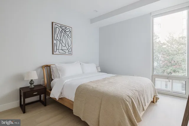 a bedroom with a bed and a large window