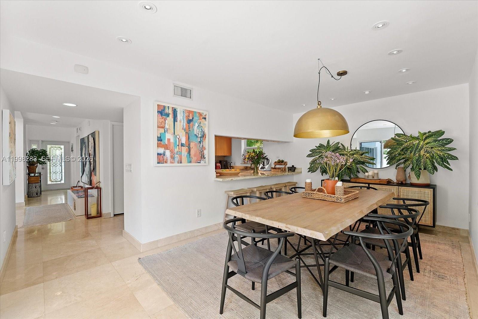 2721 Southwest 22nd Avenue, Unit A Miami, FL 33133 - Photo 12 of 36 a view of a dining room and kitchen with furniture and a chandelier