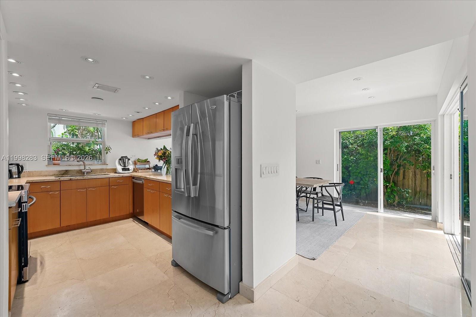 2721 Southwest 22nd Avenue, Unit A Miami, FL 33133 - Photo 14 of 36 a kitchen with a sink a refrigerator and chairs