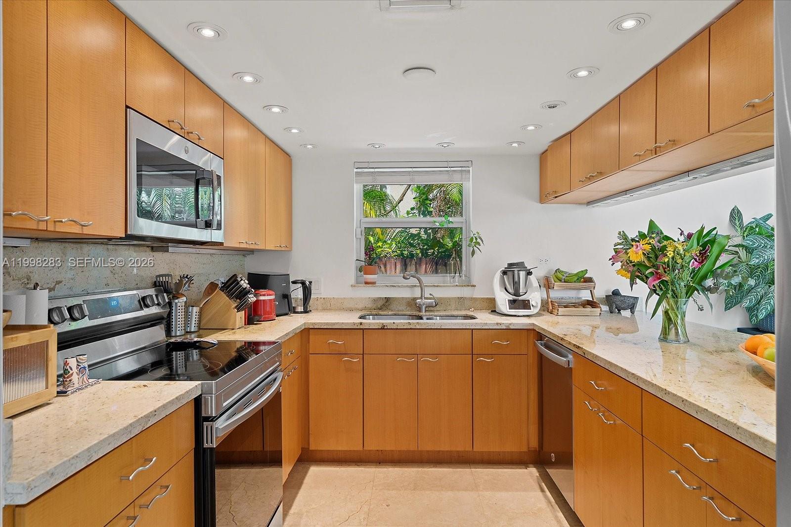 2721 Southwest 22nd Avenue, Unit A Miami, FL 33133 - Photo 15 of 36 a kitchen with stainless steel appliances granite countertop a sink stove and cabinets