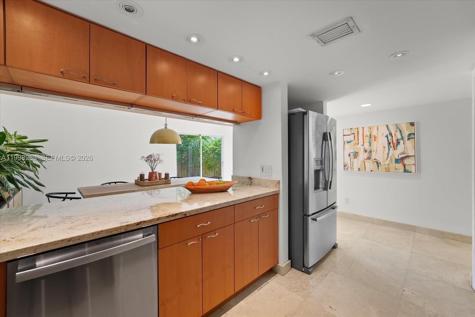 2721 Southwest 22nd Avenue, Unit A Miami, FL 33133 - Photo 16 of 36 a kitchen with stainless steel appliances granite countertop a refrigerator and a sink