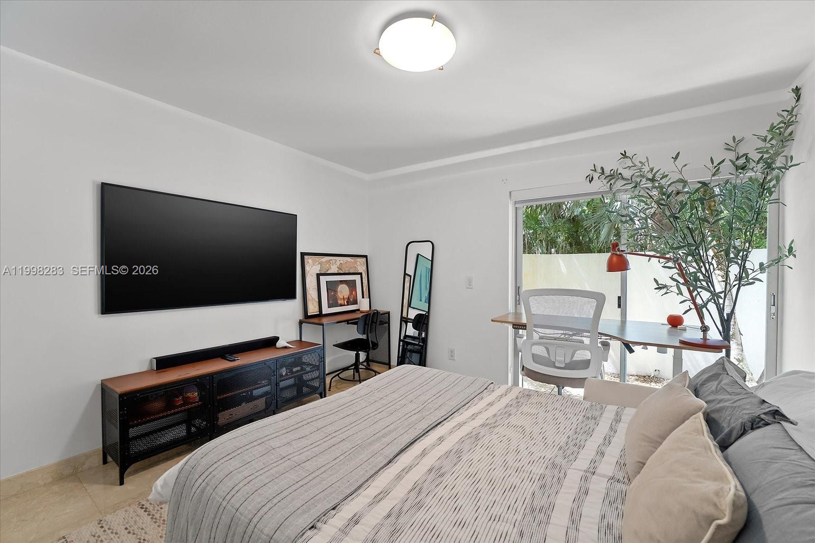 2721 Southwest 22nd Avenue, Unit A Miami, FL 33133 - Photo 18 of 36 a bedroom with a bed and a flat screen tv