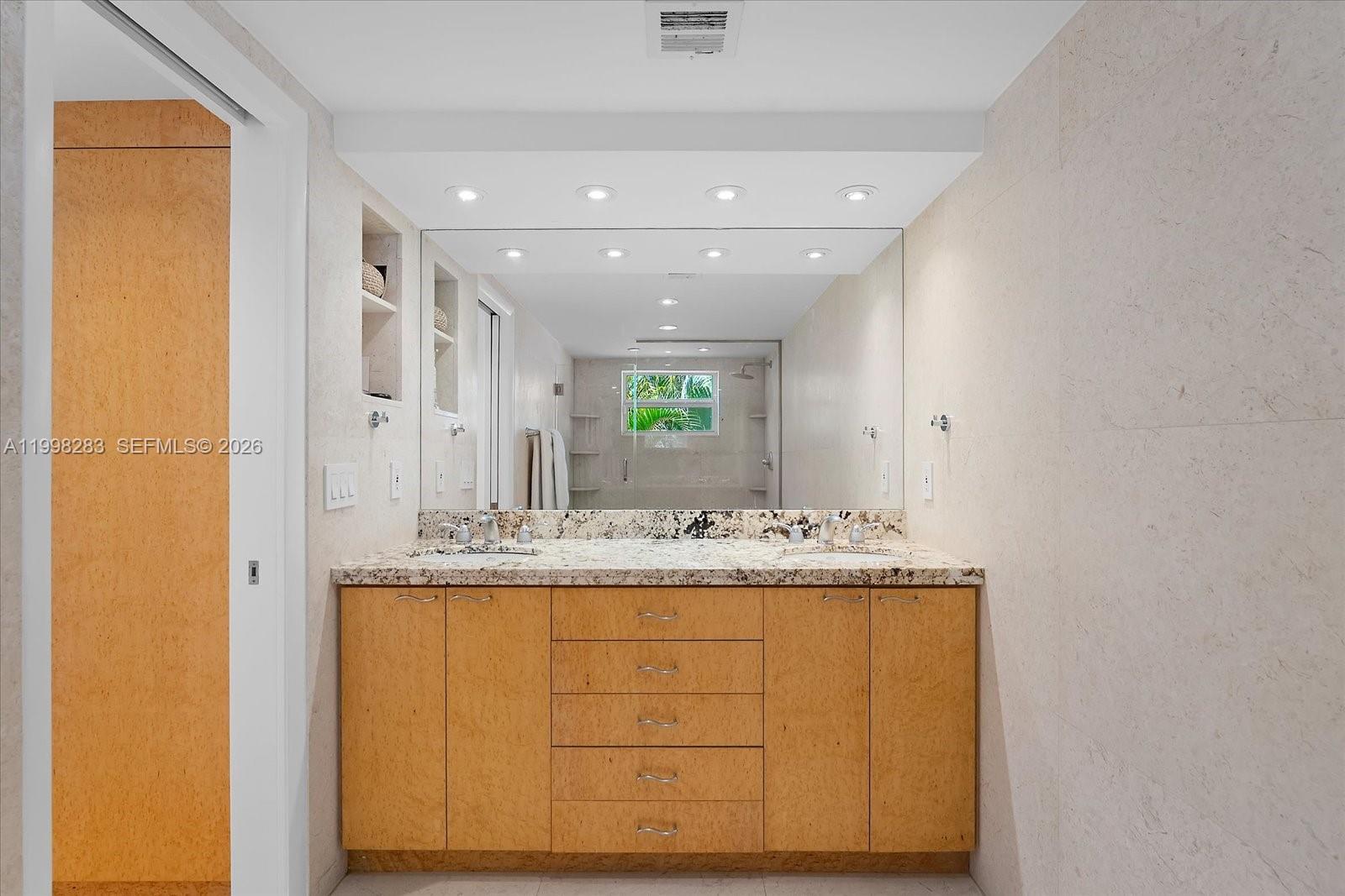 2721 Southwest 22nd Avenue, Unit A Miami, FL 33133 - Photo 27 of 36 a bathroom with a granite countertop sink and a mirror