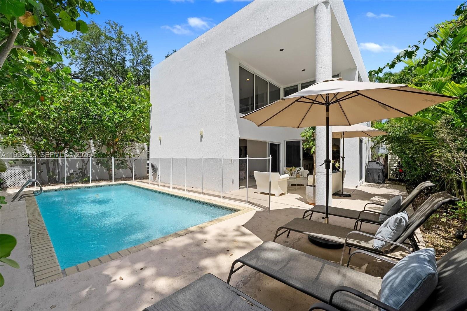 2721 Southwest 22nd Avenue, Unit A Miami, FL 33133 - Photo 6 of 36 a patio with a table and chairs under an umbrella
