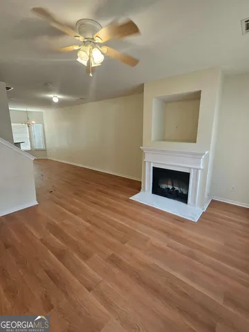 a view of empty room with wooden floor and fireplace