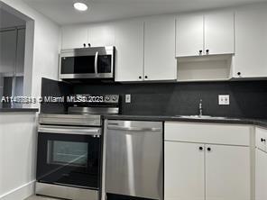 a kitchen with stainless steel appliances granite countertop a stove a microwave and oven