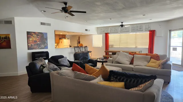 a living room with furniture ceiling fan and a window