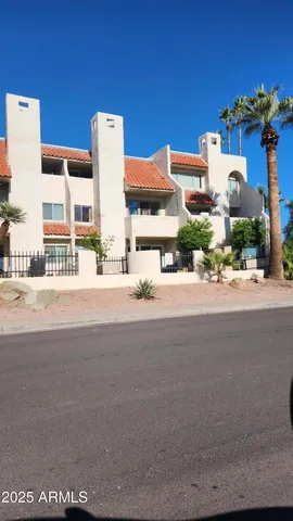 a front view of a building with streets and trees