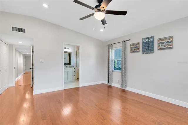 a view of a big room with wooden floor and a ceiling fan