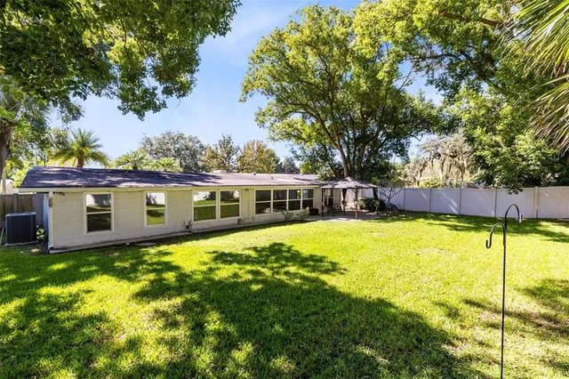 a swimming pool with some plants and large trees