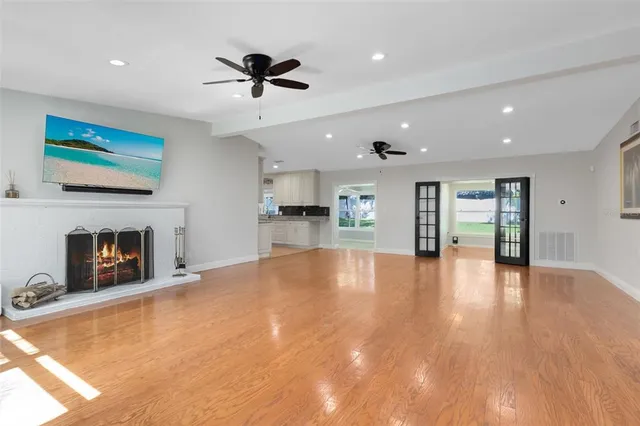 a view of an empty room with a fireplace and a window