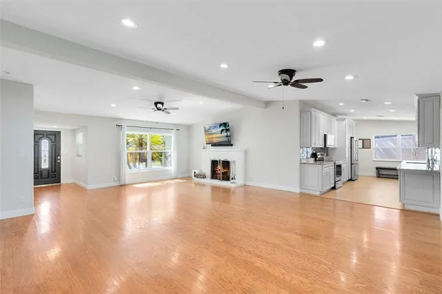 a view of an empty room with a window and wooden floor