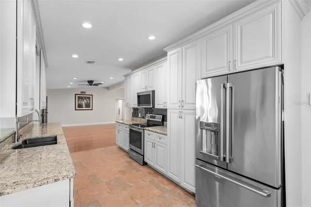 a kitchen with granite countertop a refrigerator and a sink