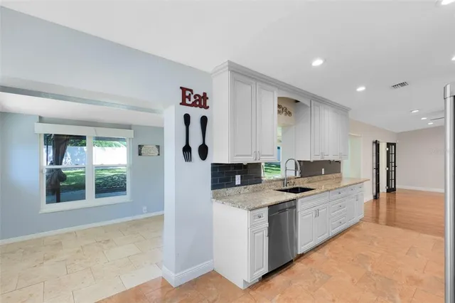 a kitchen with granite countertop a sink stove and cabinets